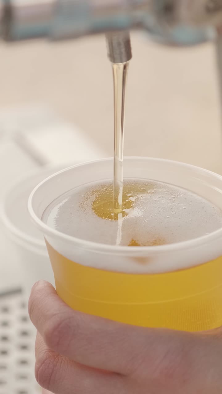 Birra versata in un bicchiere di plastica