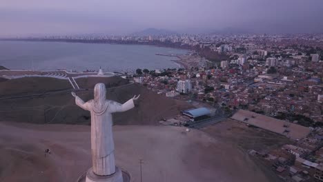 A breathtaking aerial view of a Christ statue with arms open, embracing a coastal city at twilight. Perfect for travel, editorial, and spiritual themes.