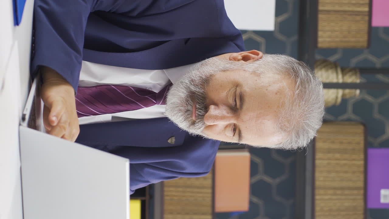 노인 사업가의 수직 비디오는 노트북에서 좋은 결과를 보고 있습니다.