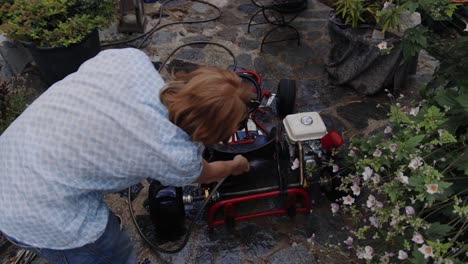 Top-down-shot-of-mechanic-washing-go-kart-in-his-backyard