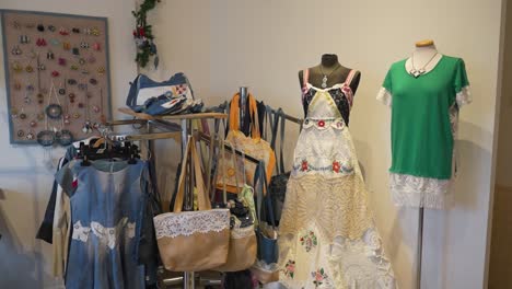 handmade vintage dresses and accessories displayed on mannequins and hangers in a boutique store