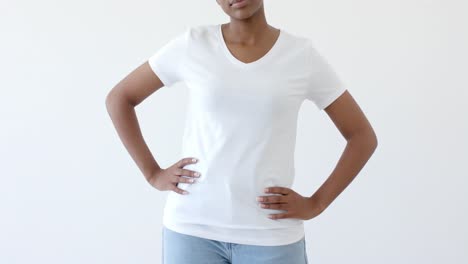 Midsection-of-african-american-woman-wearing-white-t-shirt-with-copy-space-on-white-background