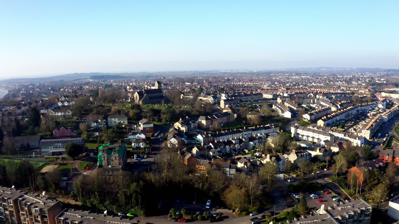 Penarth town with rows of houses and churches on a clear sunny day, aerial view