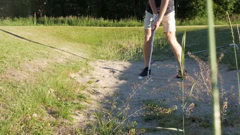 Un-Golfista-Intenta-Sacar-Un-Tiro-De-Una-Trampa-De-Arena---Búnker-Mientras-La-Pelota-De-Golf-Sale-Volando-De-La-Trampa-De-Arena---Búnker-En-Un-Día-Soleado