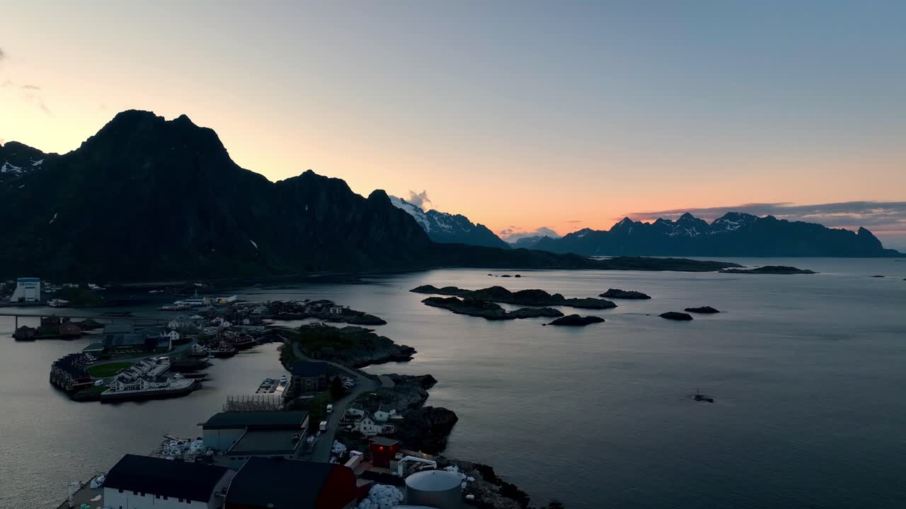Drone liitää Svinoyan yllä kohti lentokenttäsaaria kultaisen keskiyön auringon horisontin alla.