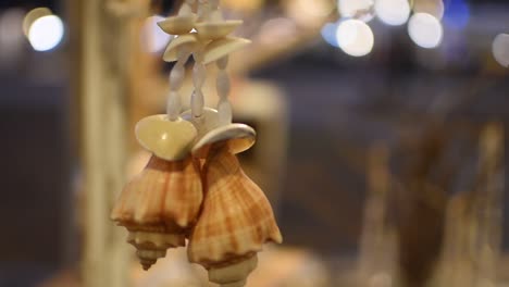 shell accessories hanging at market stall, rotating slow motion shot