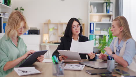 women discuss projects and analyze sales in company