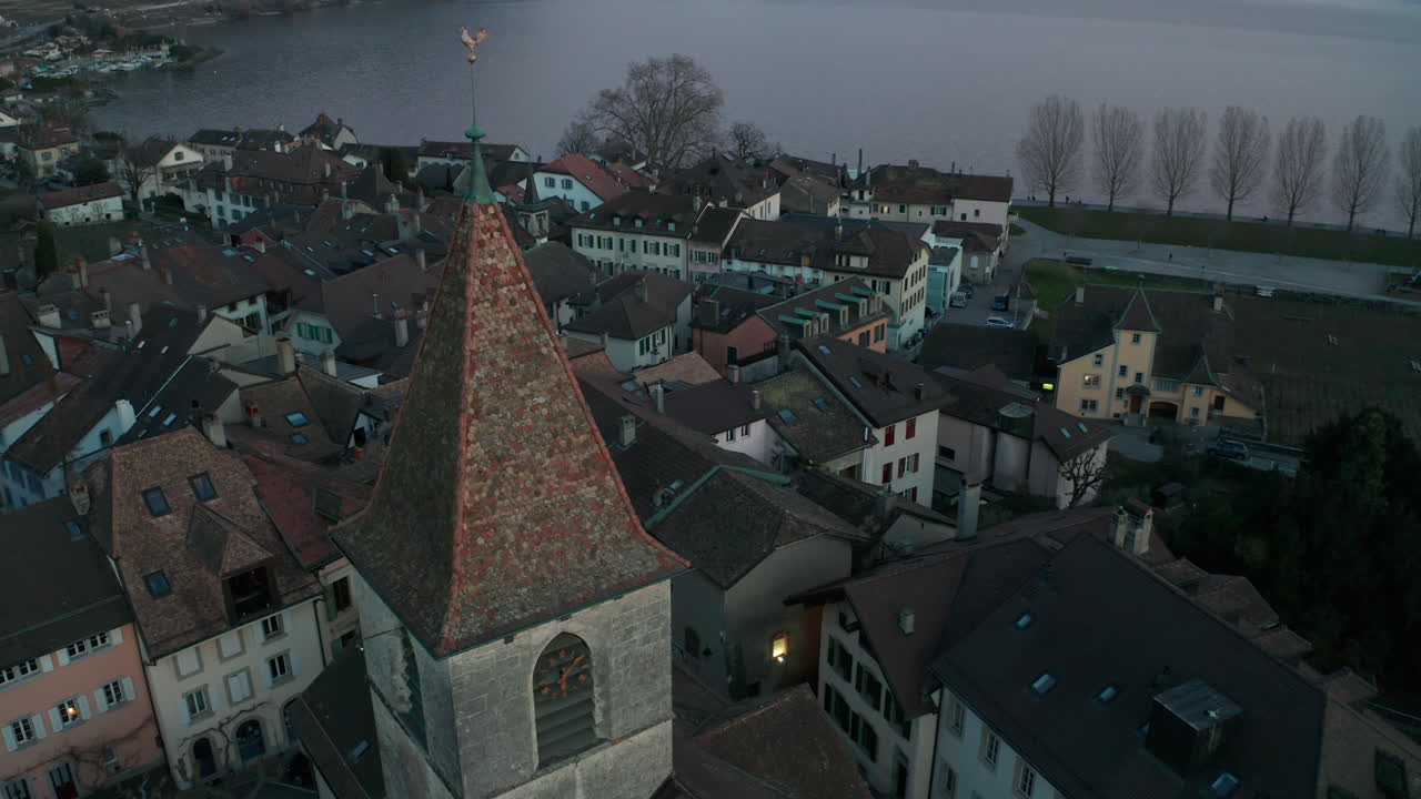 Jib down of church tower overlooking small town near lake