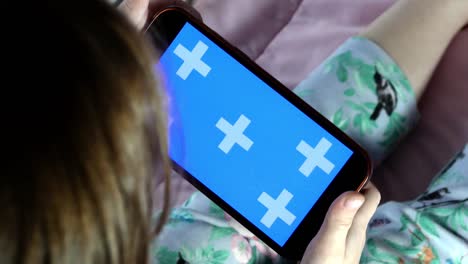 un teléfono inteligente en manos de un niño, la pantalla está retroiluminada con una indicación de color azul.