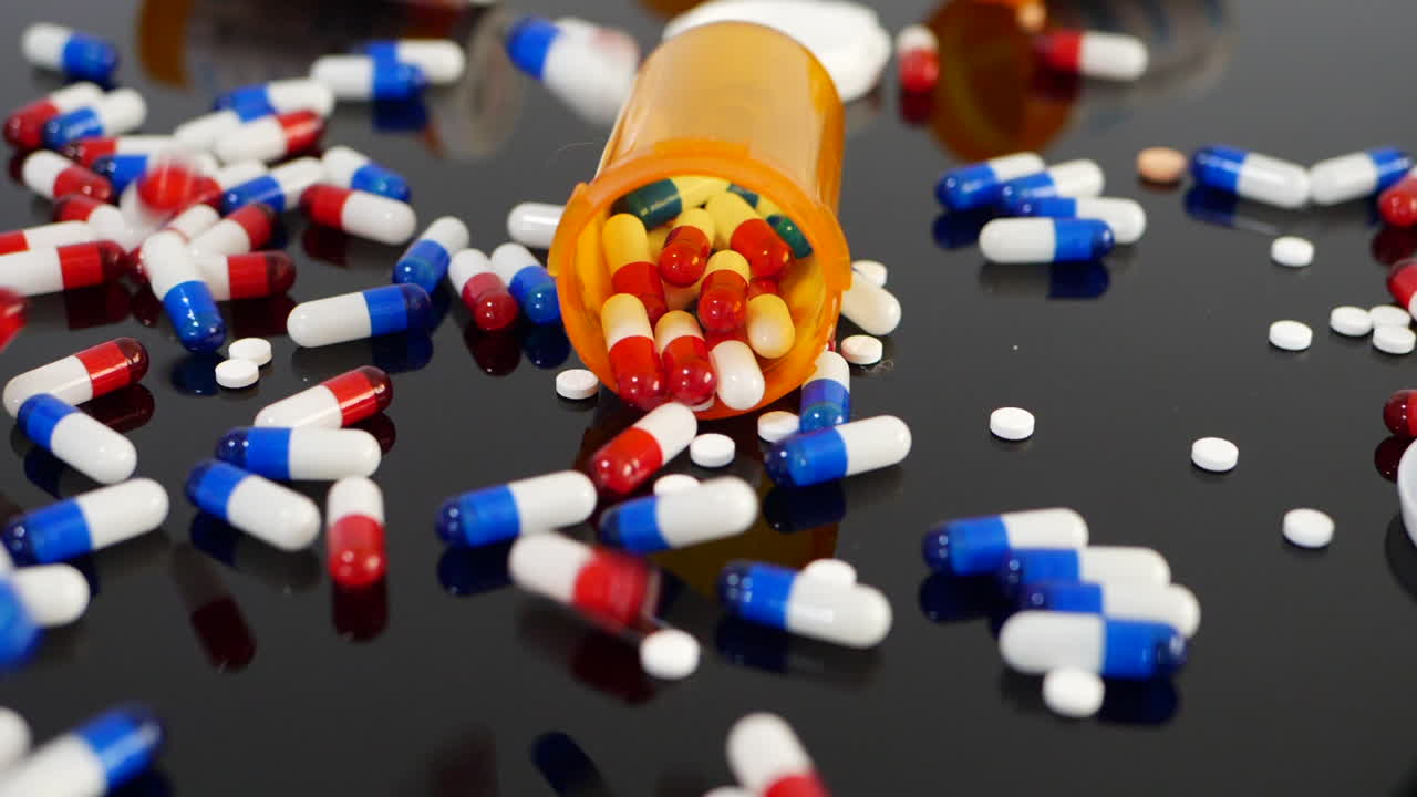 Many prescription pills, drugs and antidepressants falling in slow motion on an orange pharmacy medicine bottle