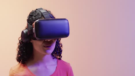 video of biracial woman using vr headset on beige background