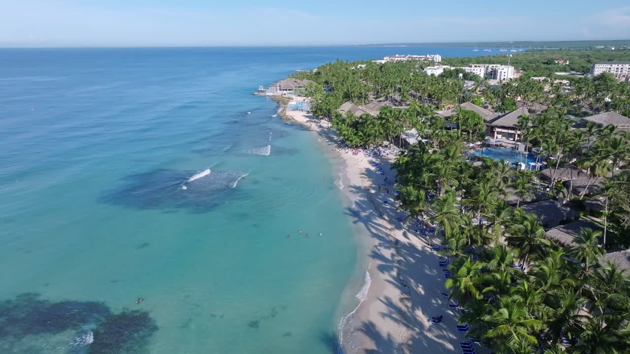 Aerial view of a tropical beach resort with turquoise water and palm trees