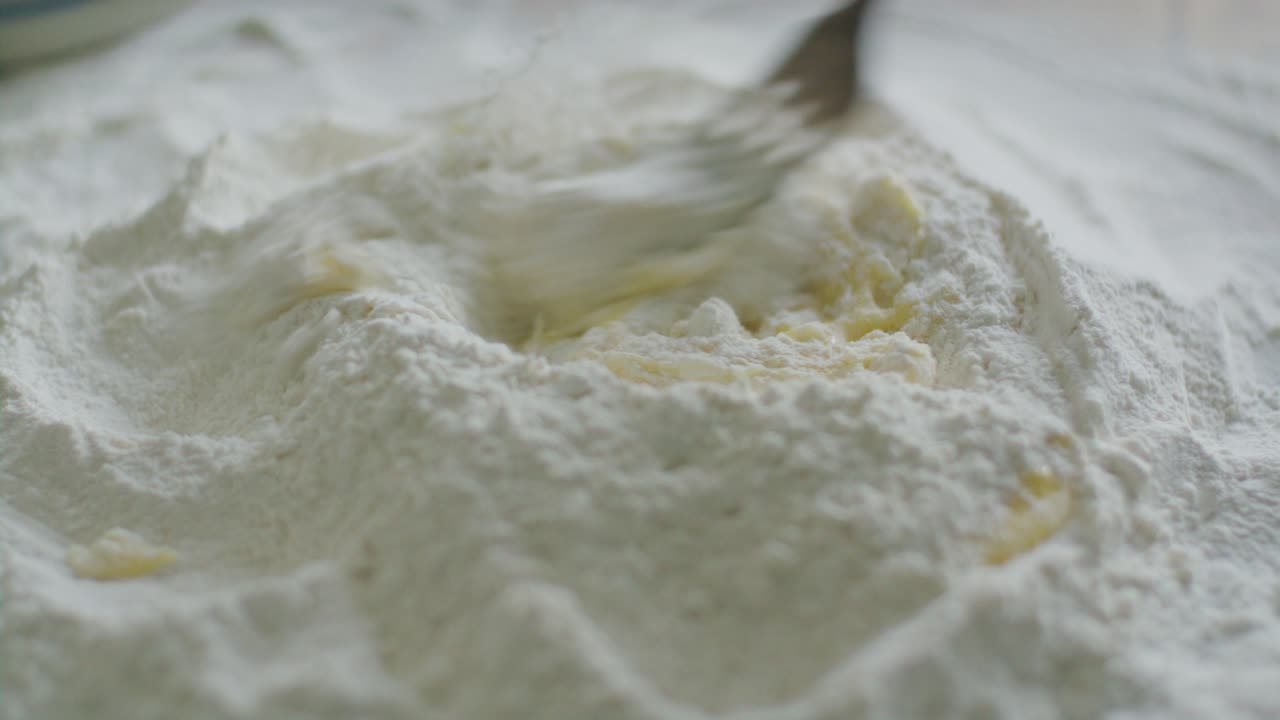Fork Stirring Eggs in Well of Flour