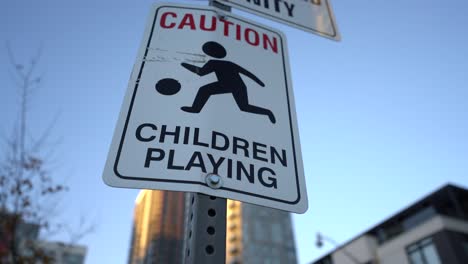 close up pan of caution, children playing sign near park in neighbourhood