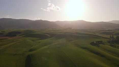 Soft-rolling-hills-in-front-of-mountain-range-during-golden-hour