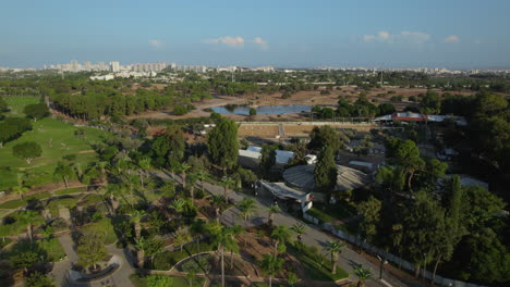 Aerial-view-of-the-Ramat-Gan-Safari-above-the-national-park,-the-horse-farm-and-the-hippopotamus-pond---push-in-shot