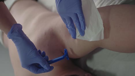 man getting underarm hair removal with razor