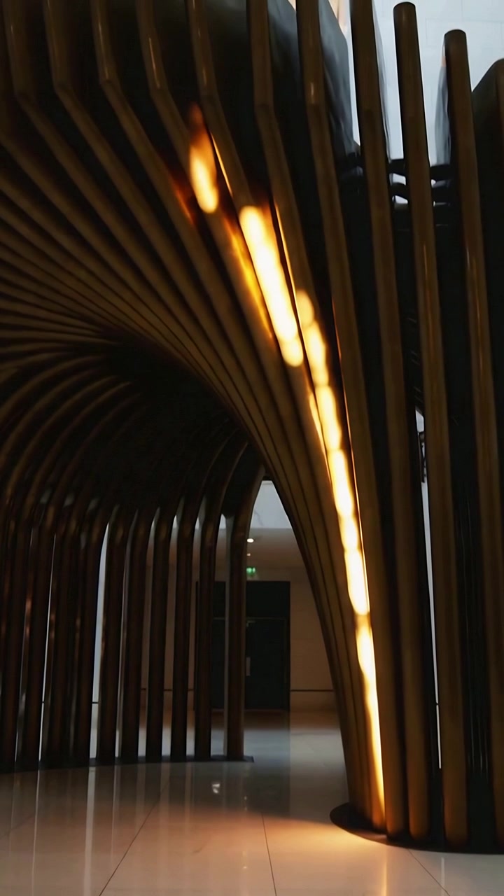 Vertical video: Tilting camera revealing wooden slatted arch in lobby, showing LED glow and form