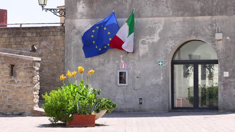 european and italian flags waving outside building