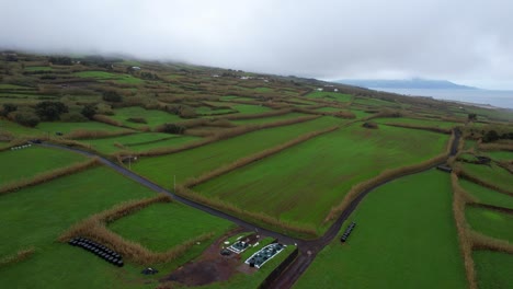 aerial of green patched meadow of farming land in faial on cloudy day