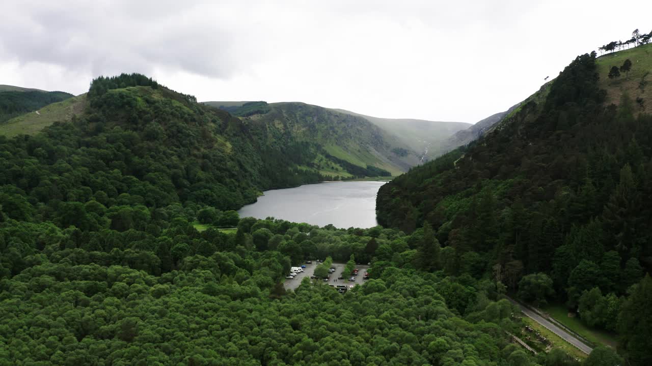 Drone shot of Glendalough, Ireland's Upper Lake surrounded by forests.