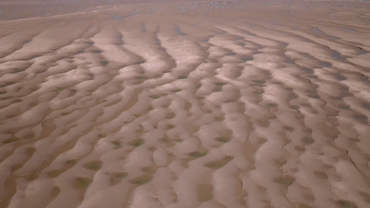 Rippled sands and seawater pools on tidal flats on a sunny day. Fleetwood, Lancashire, UK.