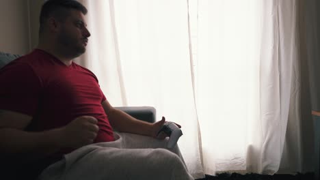 joven celebrando una victoria en videojuegos en su sala de estar en cámara lenta