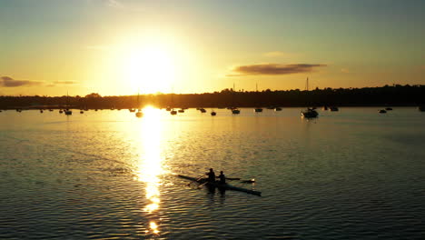 aerial sunset shot above auckland port with double scull in forefront