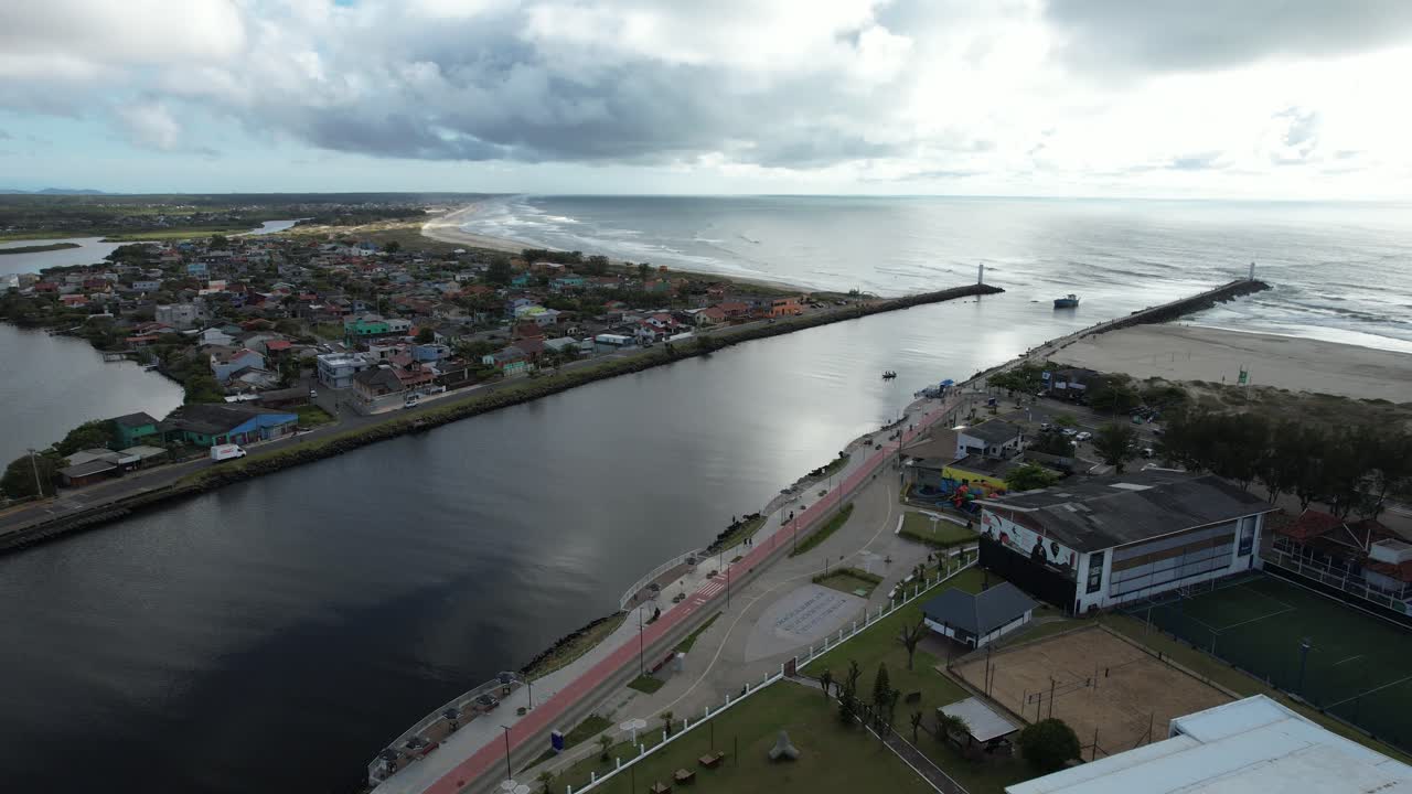 Side tracking with drone passing over a beautiful canal that reaches the sea, southern Brazil