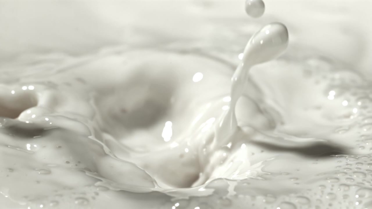 Close-Up of Fresh Milk Pouring and Splashing in Slow Motion