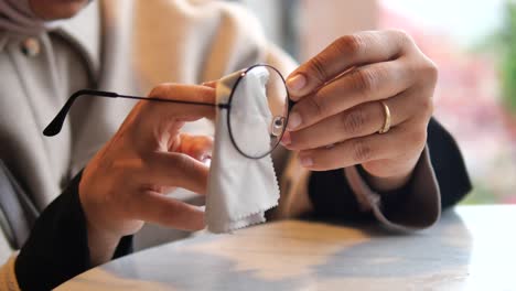 woman cleaning her eyeglasses