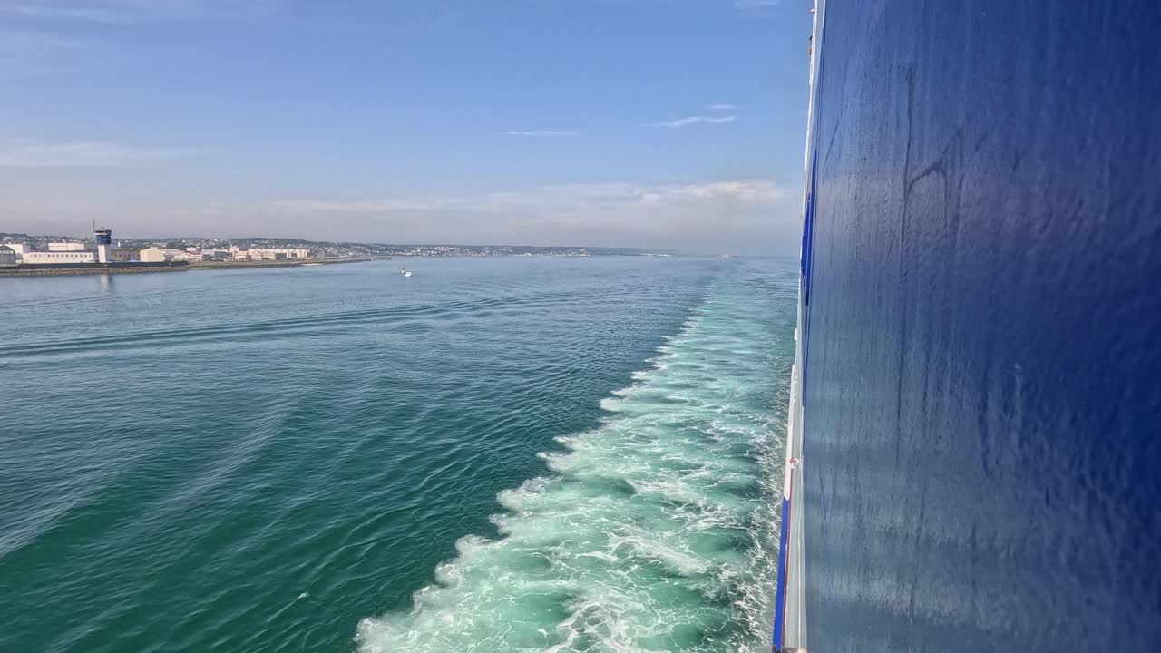Steel hull of huge transport ferry leaves wake in ocean, leaving port
