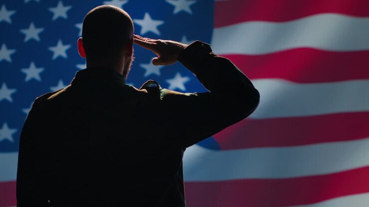 Patriota americano che saluta con il gesto della mano verso la bandiera degli Stati Uniti
