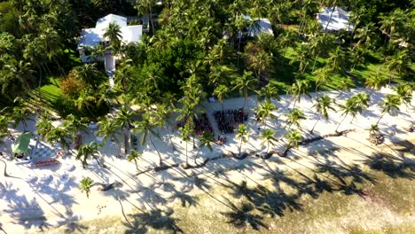 Overhead drone angle of white sand clearing surrounded by tropical trees in Cheeca Lodge with people gathered for wedding