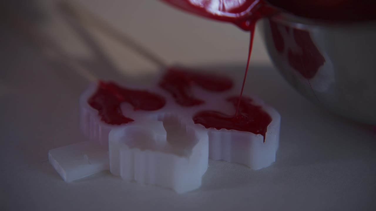Red Liquid Being Poured into White Craft Molds