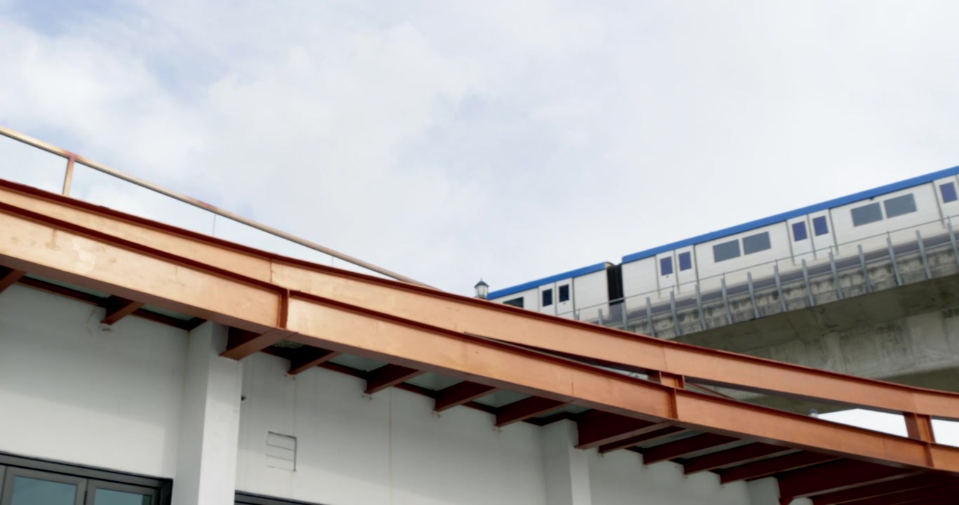 Treno elettrico che attraversa un ponte fluviale a Bangkok, parte dell'efficiente sistema di trasporto urbano della città. Il treno è diretto verso la stazione