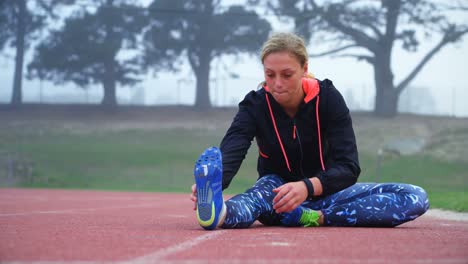 Front-view-of-young-Caucasian-female-athlete-exercising-on-a-running-track-4k