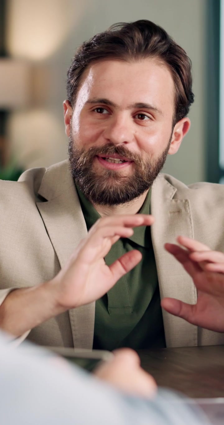 Uomo d'Affari con Barba Durante una Conversazione Professionale in Ufficio