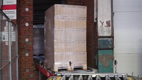 pallet with boxes on conveyor belt in warehouse