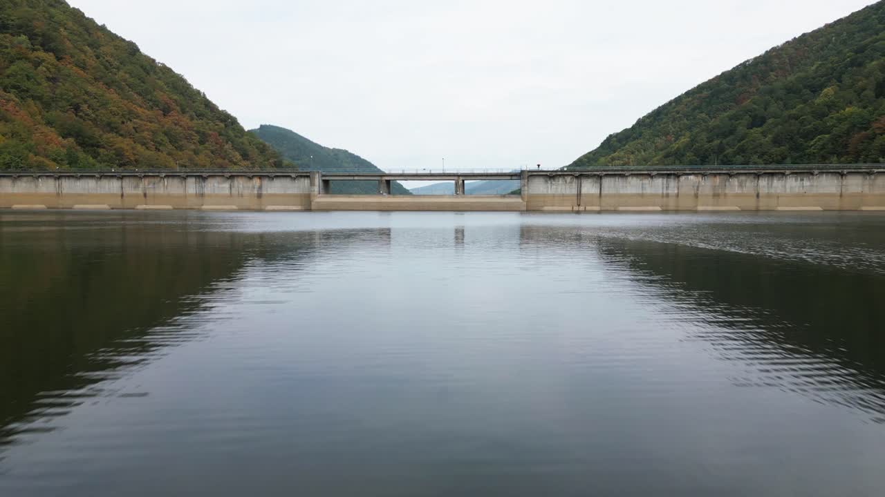 drone flies over a big blue sea or reservoir in a valley and a bird flies over, carpathians, romania, europe, drone, summer