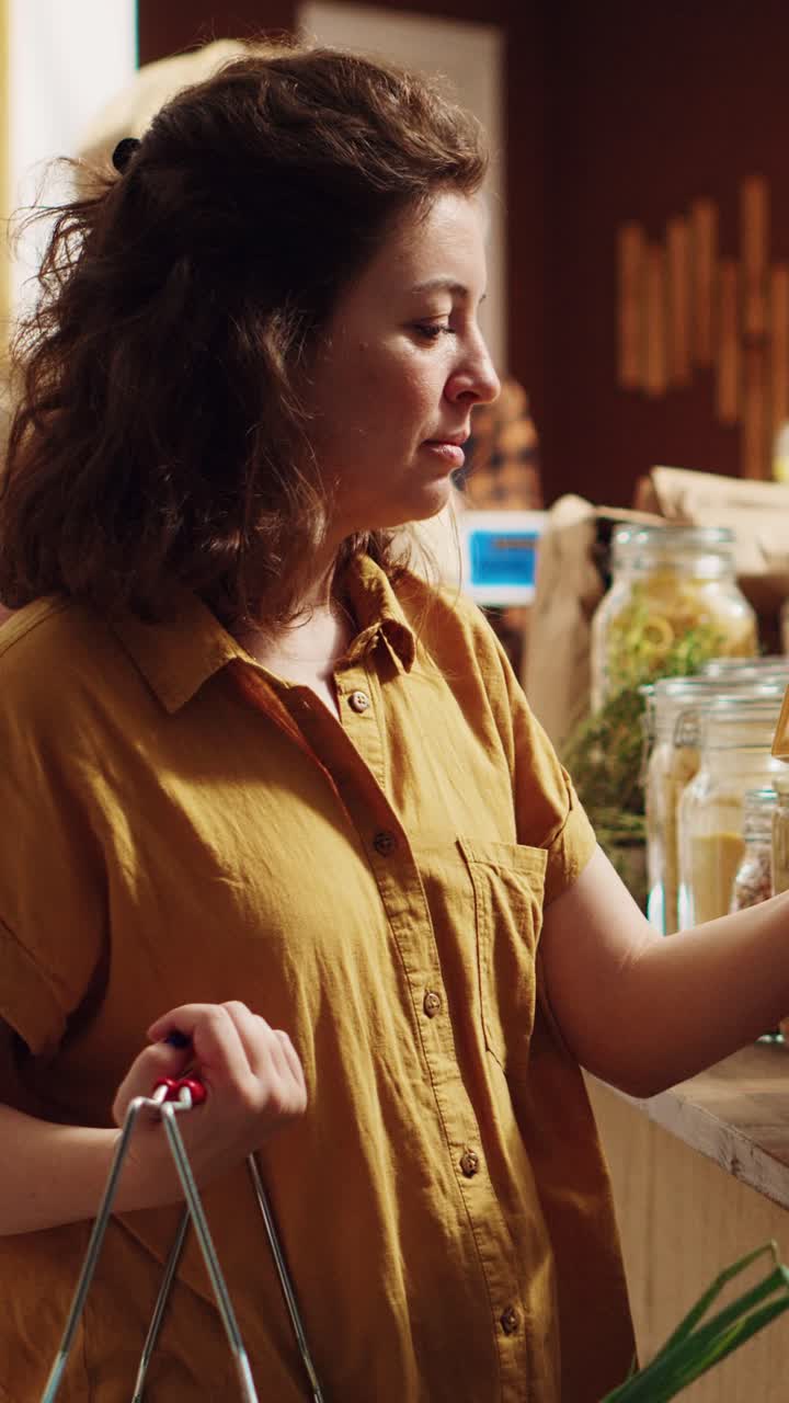 Vídeo vertical: un cliente compra comida en tarros sin plástico