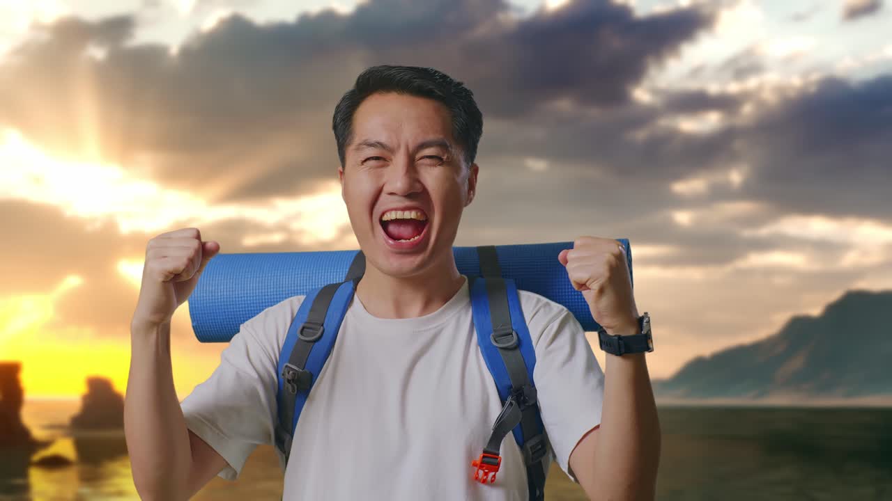 해변에서 등반 배낭을 메고 목표 달성 성공을 외치는 아시아 남성 등반가의 클로즈업
