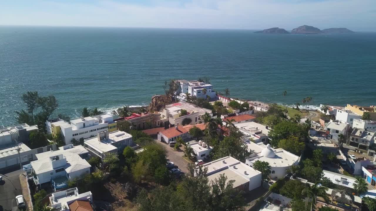 Luxury homes in Mazatlan neighborhood with ocean views on a summer day, aerial