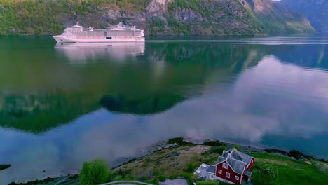 Luxury-cruise-ship-in-the-fjord-near-the-village-of-Flame,-Norway---aerial-follow