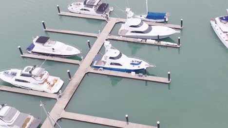 aerial footage captures boats docked at a marina in port douglas, australia. calm waters and clear skies create a serene atmosphere