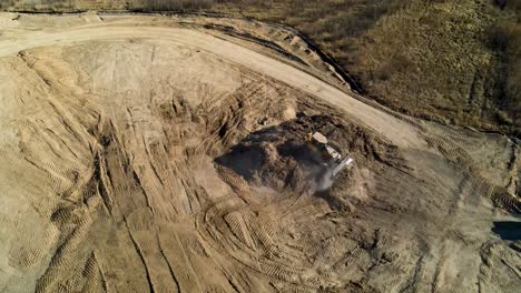 Bulldozers-moving-dirt,-earth,-sand-and-dust-in-at-a-large-construction-site---aerial-view