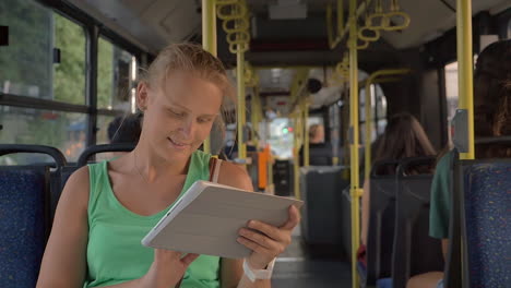 happy pretty blonde with tablet pc riding in the bus