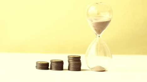 hourglass on table, sand flowing through the bulb of sandglass