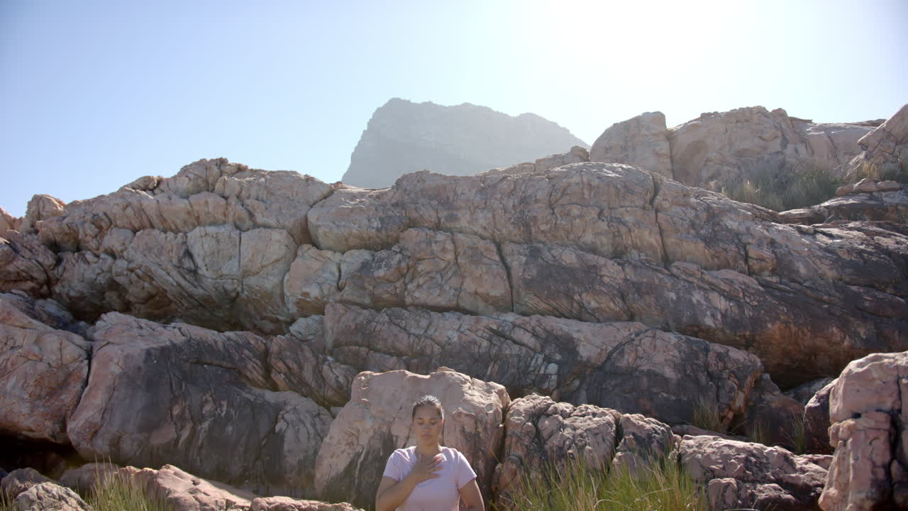 Hiking in mountains, woman resting on rocks and enjoying nature, copy space