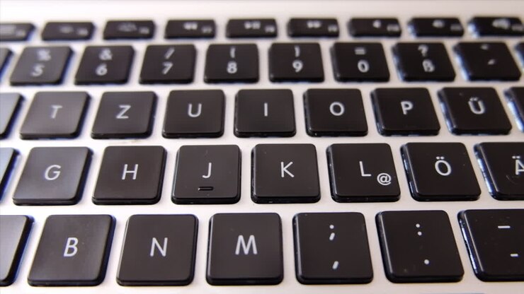 Nærbillede af et sort tastatur på en bærbar computer i dagslys